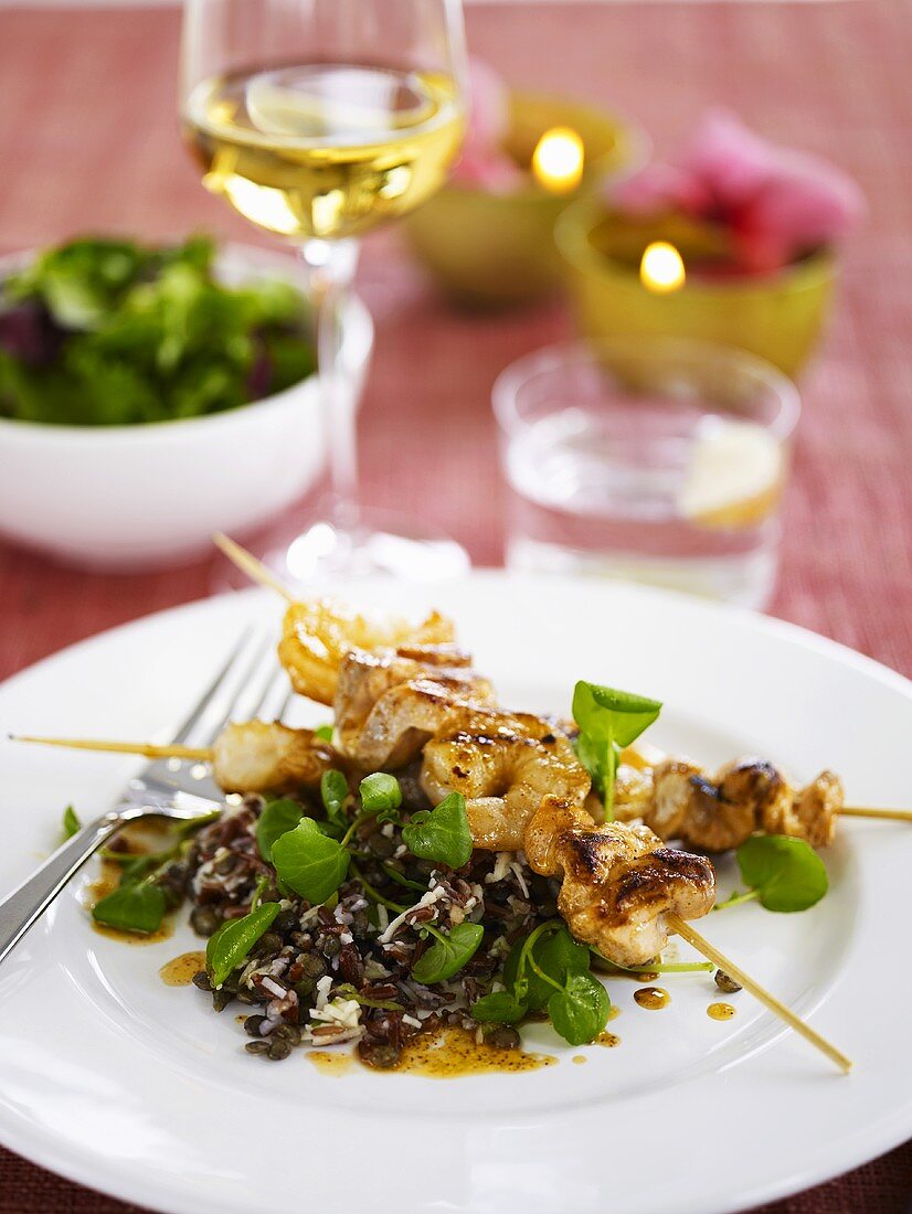 Seafood kebabs on lentils and rice