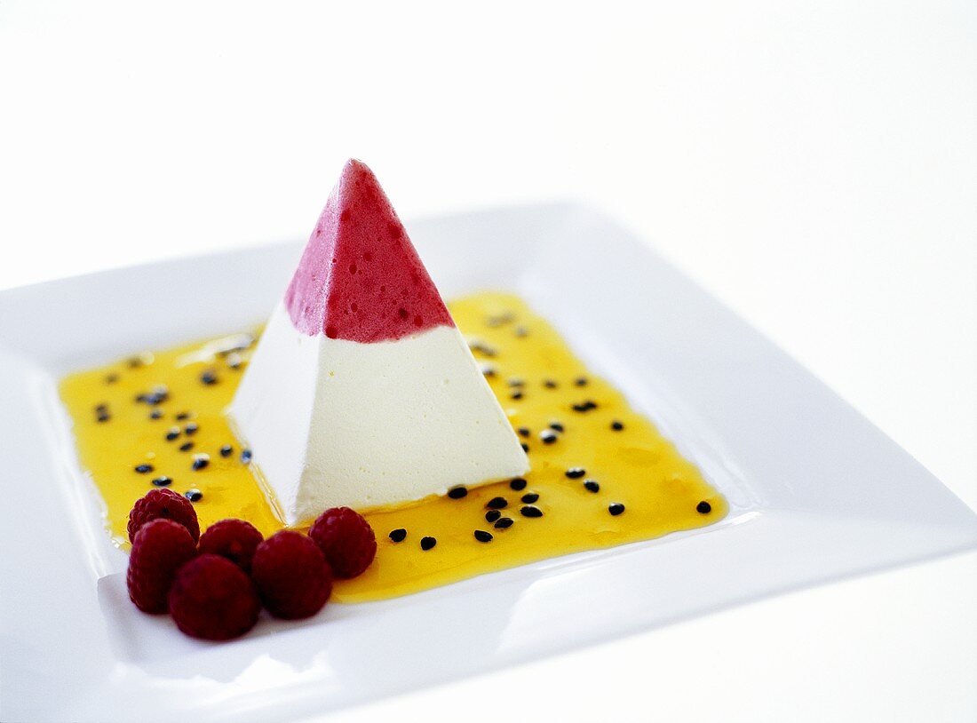 Ice cream pyramid with passion fruit sauce and raspberries