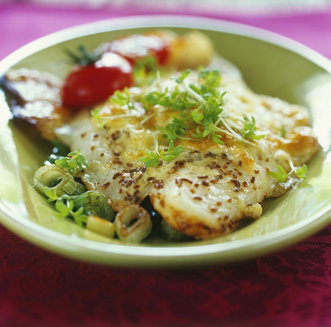 Baked fish fillet with caraway seeds and cress