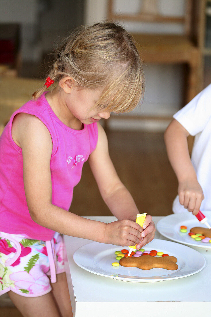 Girl and boy decorating gingerbread men