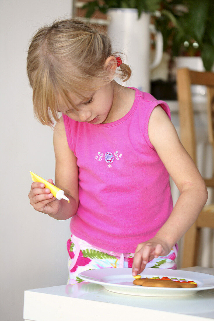 Girl decorating a gingerbread man