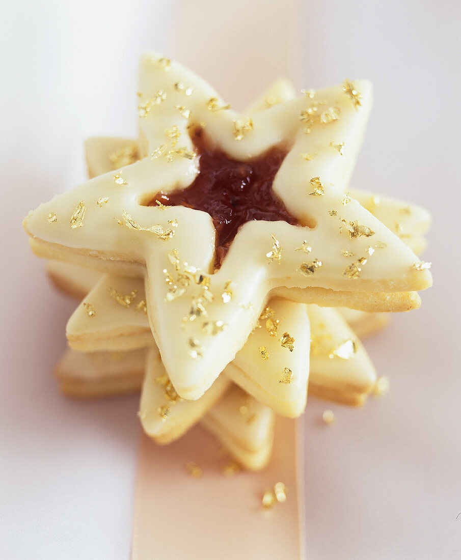 Star-shaped biscuits with jam filling, lemon icing & gold dust