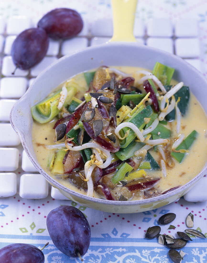 Leeks with sprouts and damsons in coconut curry sauce