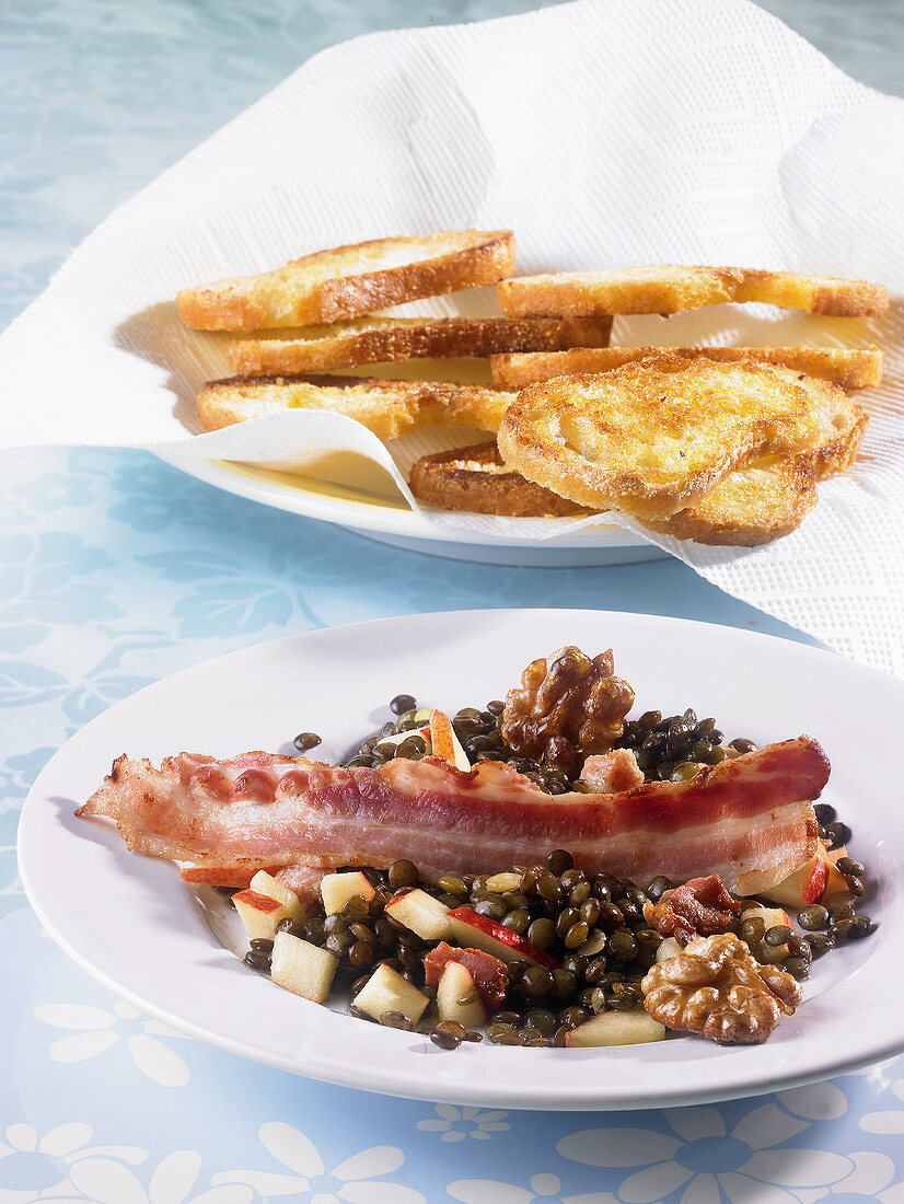 Lukewarm lentil salad with fried bacon and toasted bread