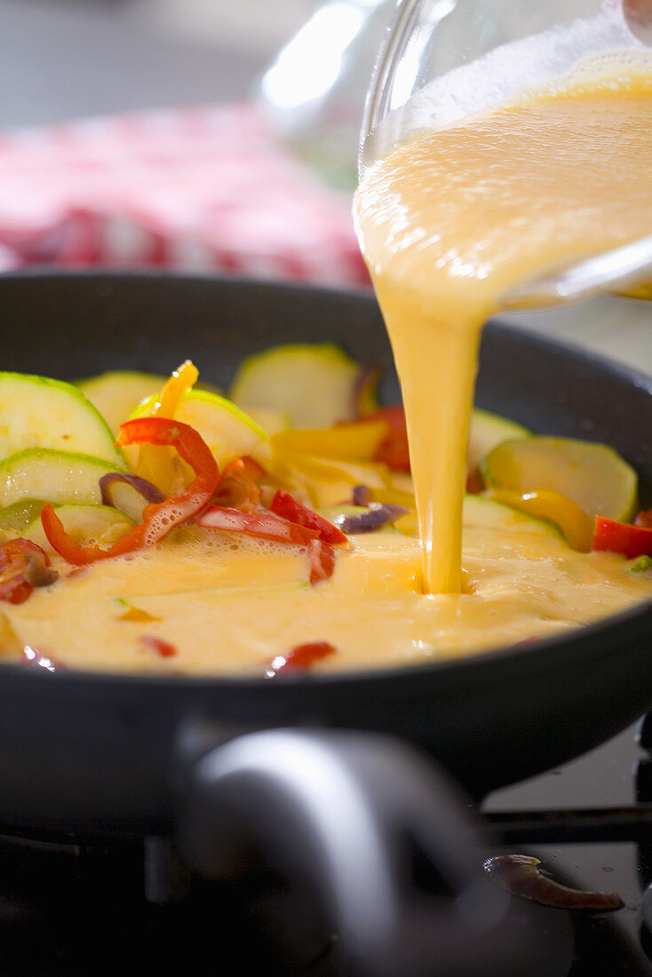 Making a frittata: pouring beaten eggs into the frying pan