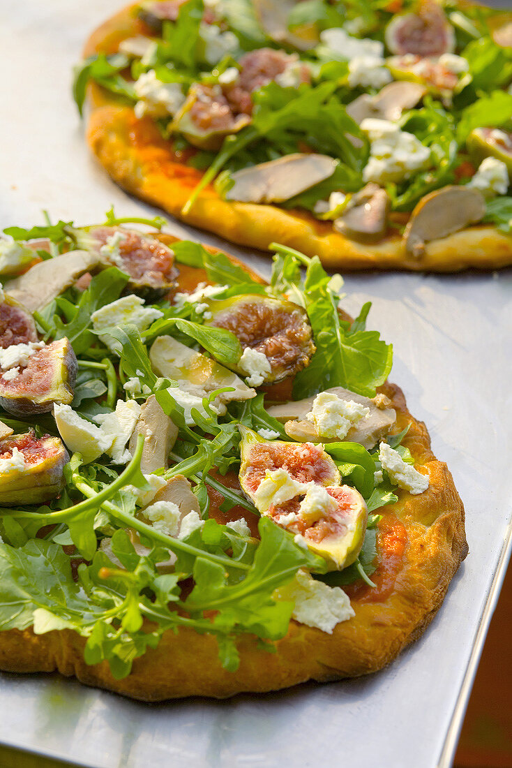 Pizza topped with foie gras, rocket and figs
