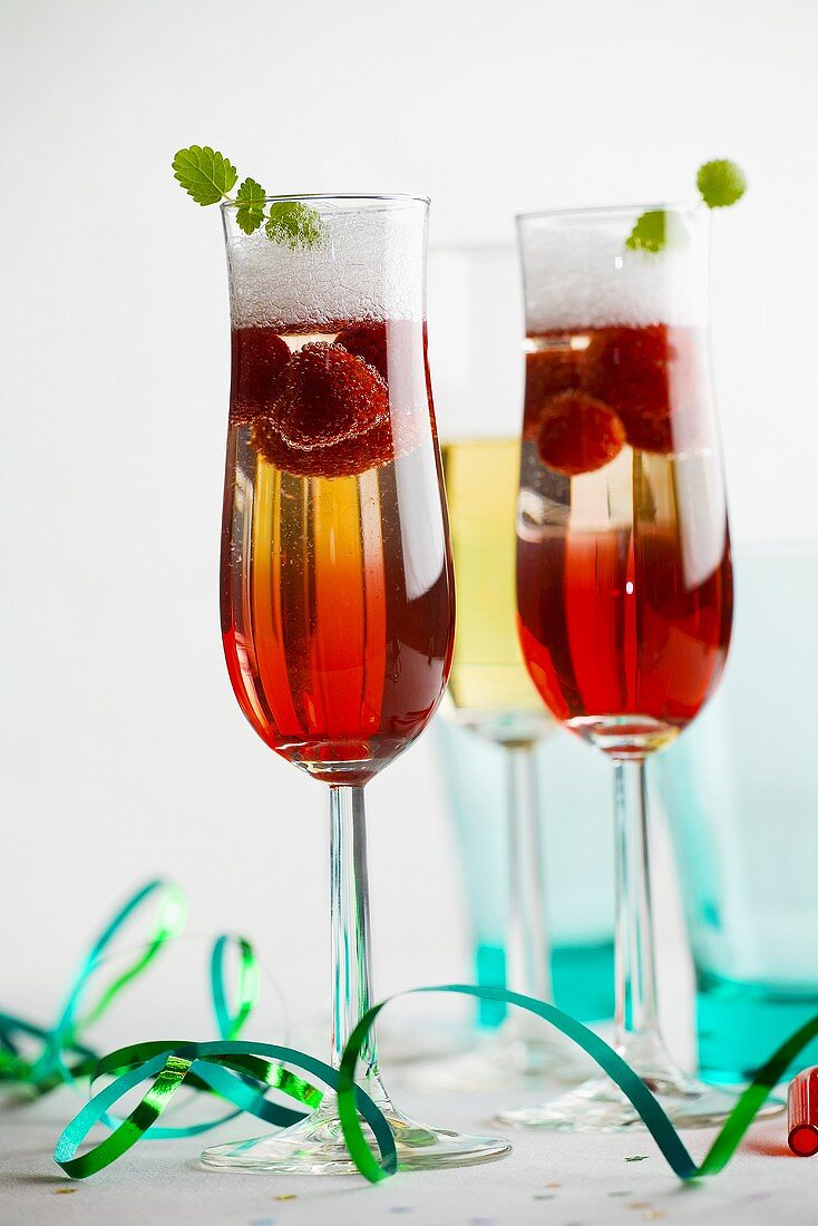 Champagne with raspberry syrup and raspberries