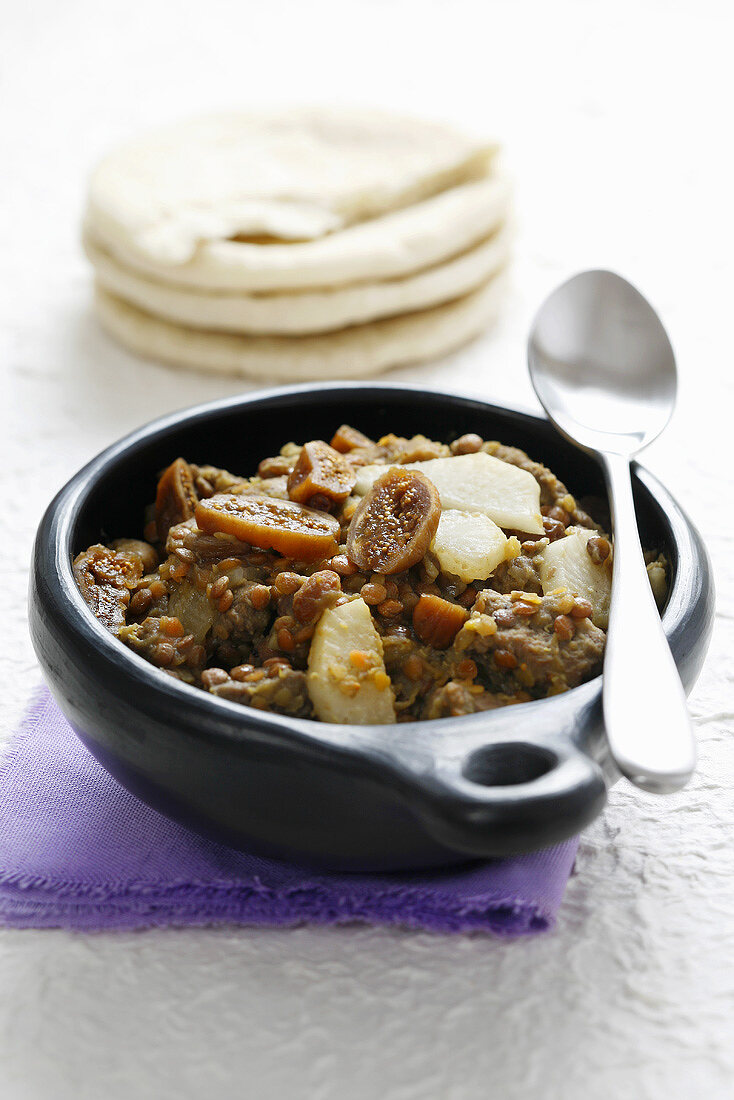 Beef and lentil stew with dried figs and pita bread