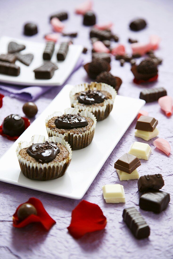 Pieces of chocolate and chocolate buns with rose petals