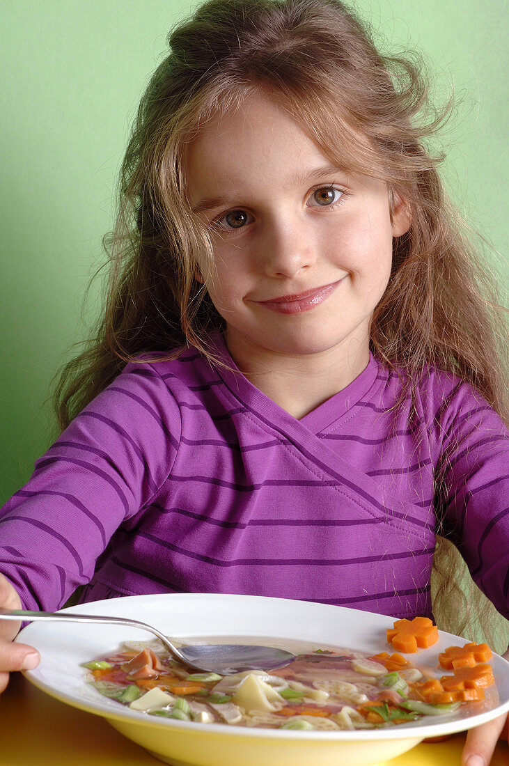 Girl eating vegetable soup