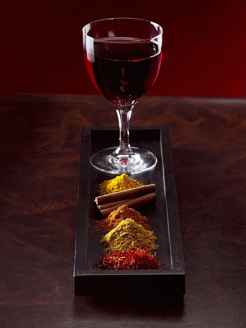A glass of red wine and spices