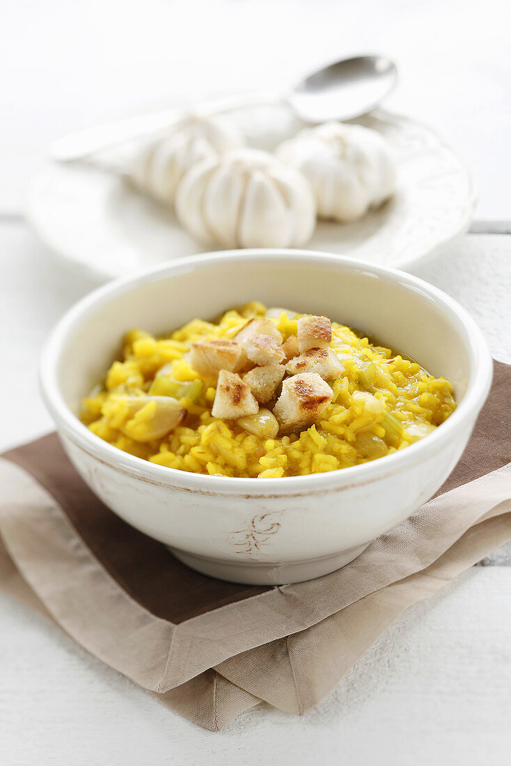 Saffron rice soup with garlic and croutons