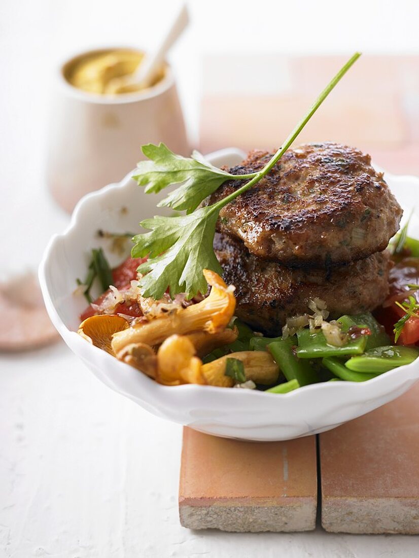 Meat patties with chanterelles, beans and tomatoes