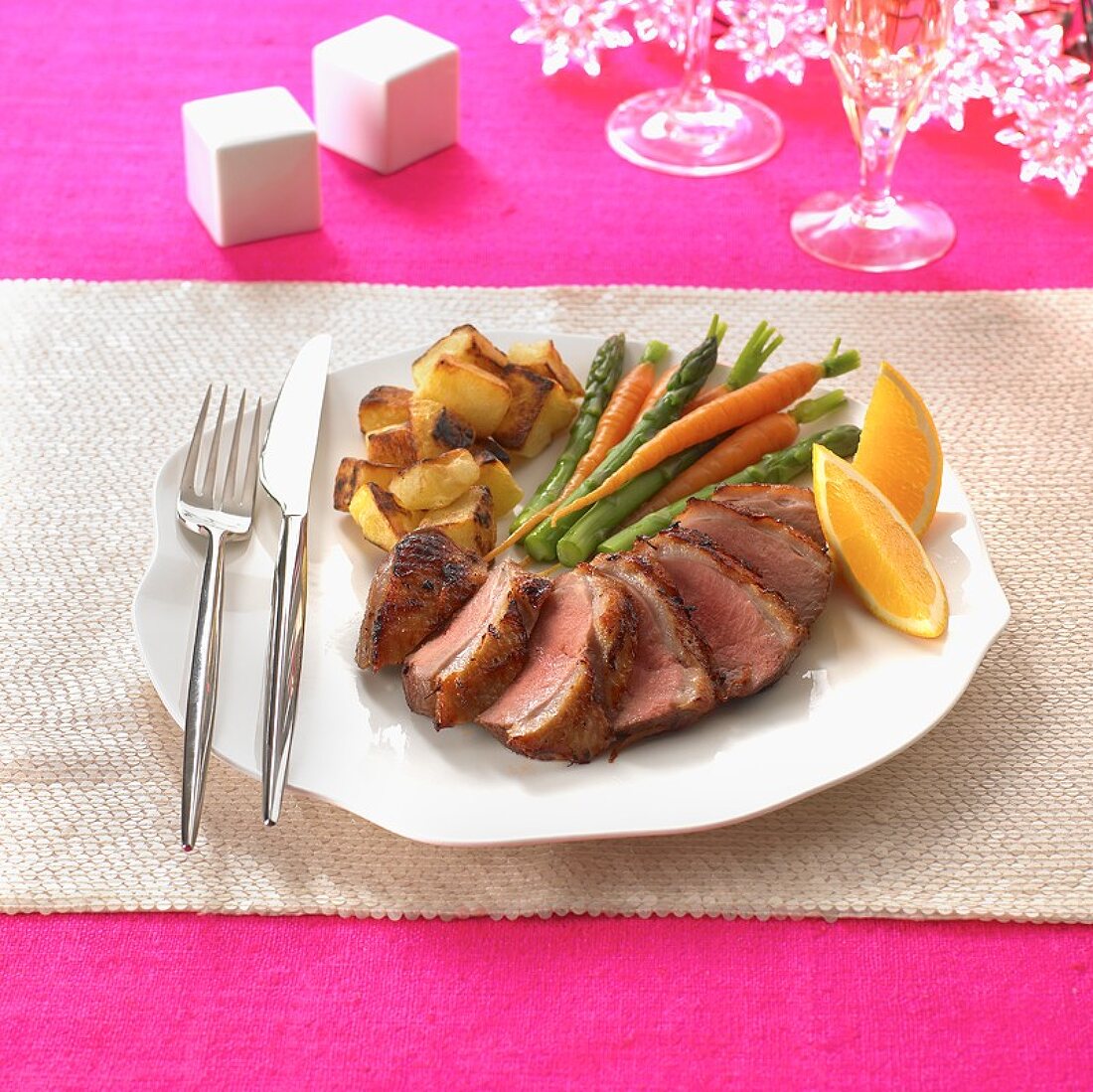 Roast duck breast with orange wedges and vegetables