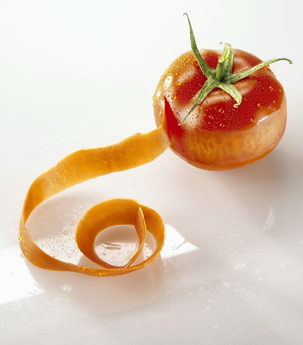 A tomato, partly peeled