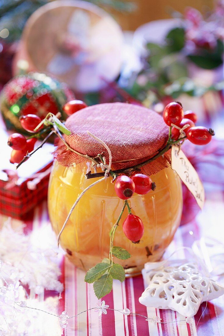 Jar of jam decorated with rose hips (Christmas gift)