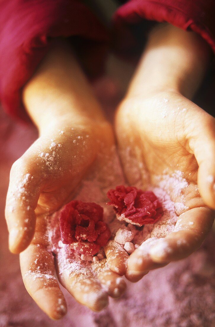 Hände halten kandierte Rosen