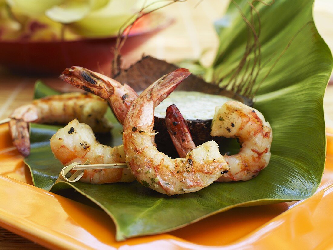 Grilled coconut prawns with coconut dip on banana leaf