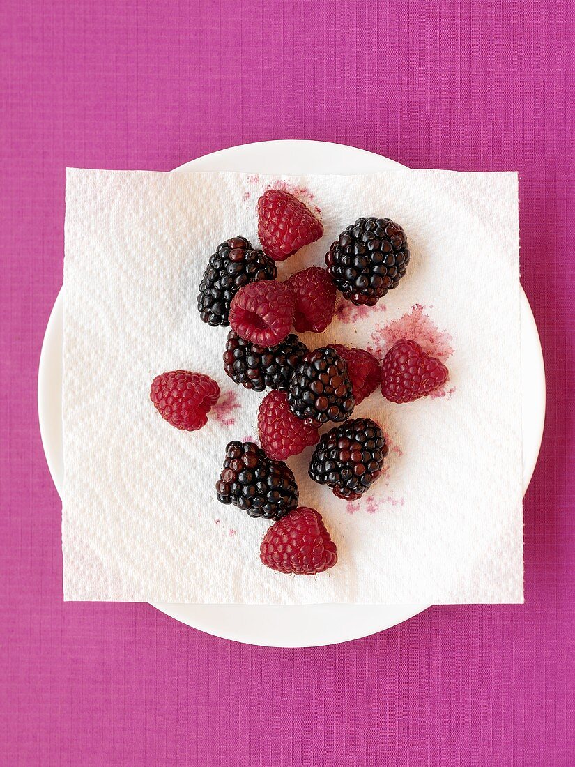 Frische Himbeeren und Brombeeren auf Teller mit Serviette