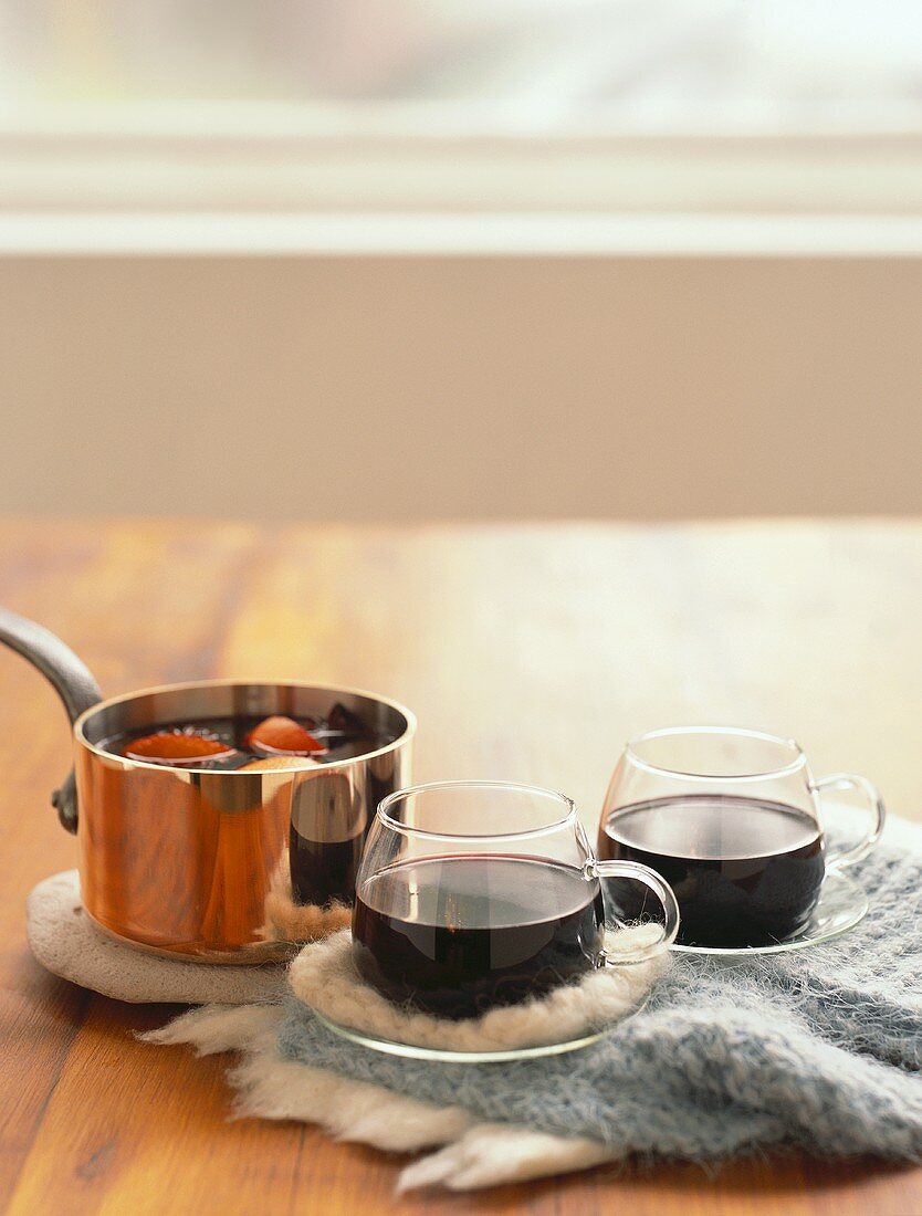 Mulled wine in glass cups and in copper pan