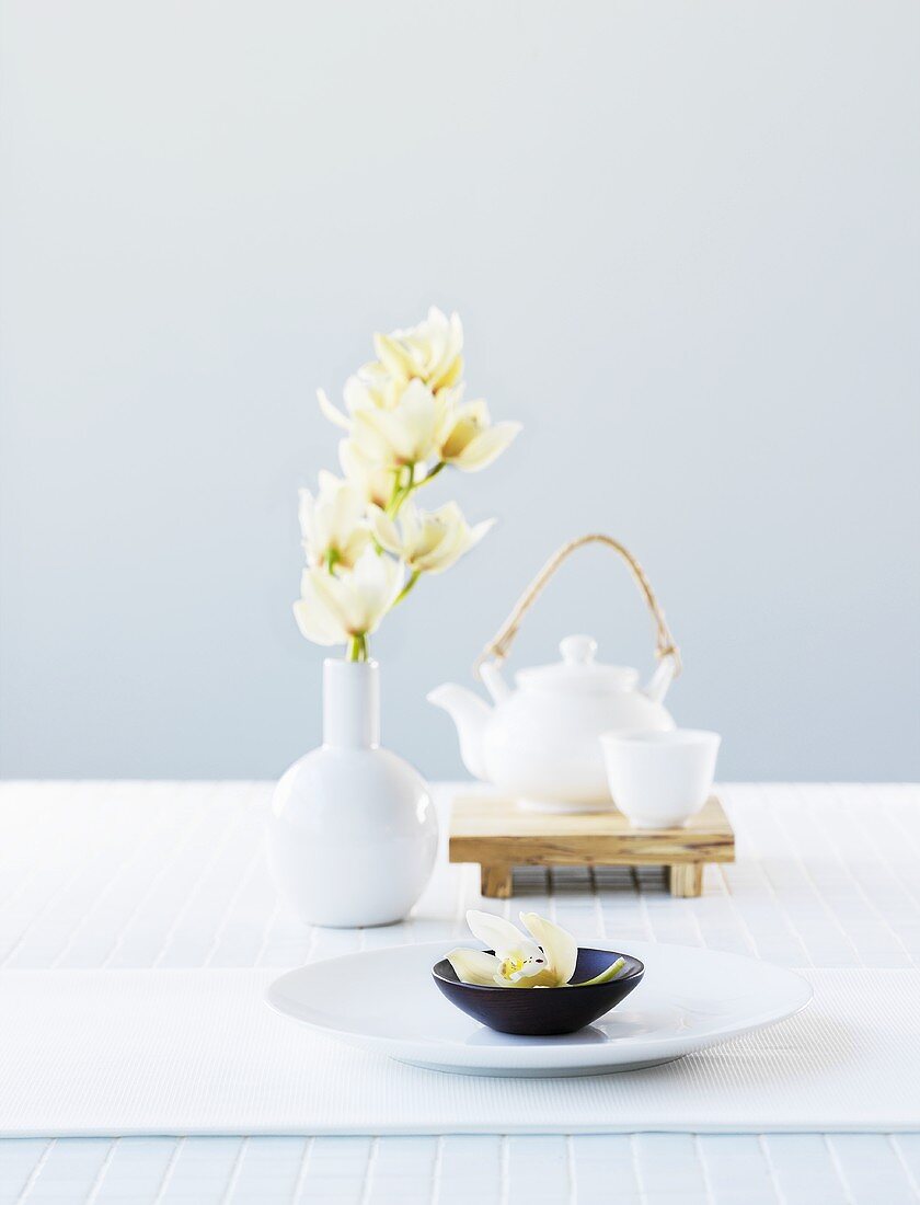 Asiatische Schale, weiße Orchideen und Teekanne