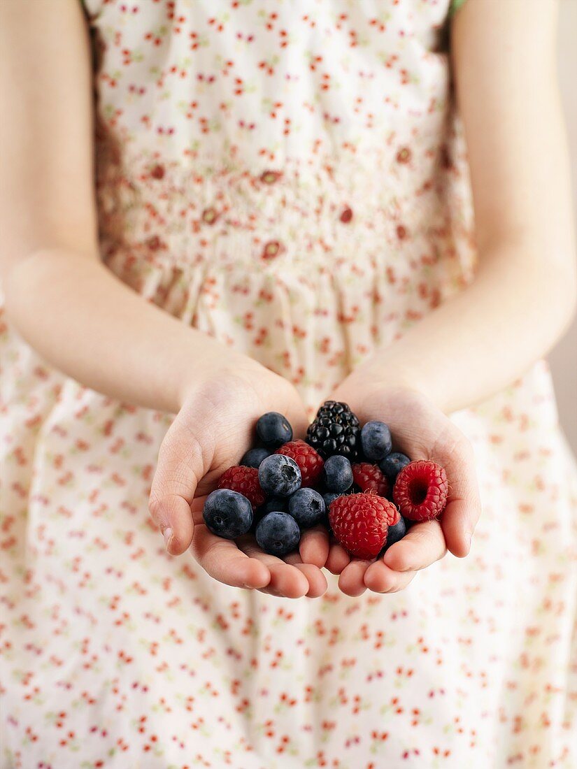 Mädchen hält frische Beeren in den Händen