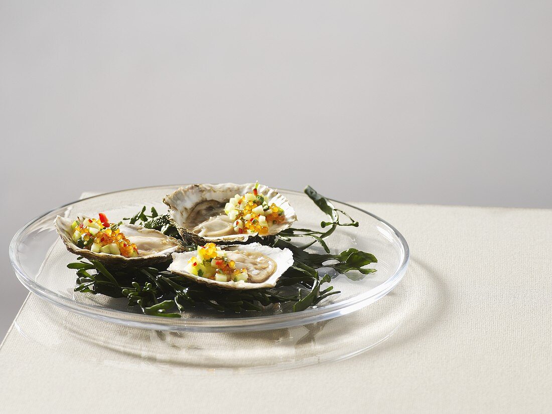 Oysters with cucumber and trout caviar on seaweed