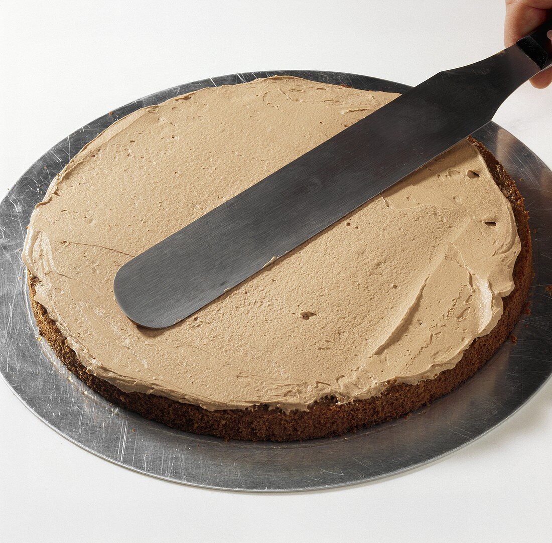 Spreading a sponge base with chocolate cream