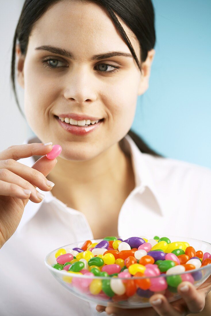Young woman holding a dish of jelly beans