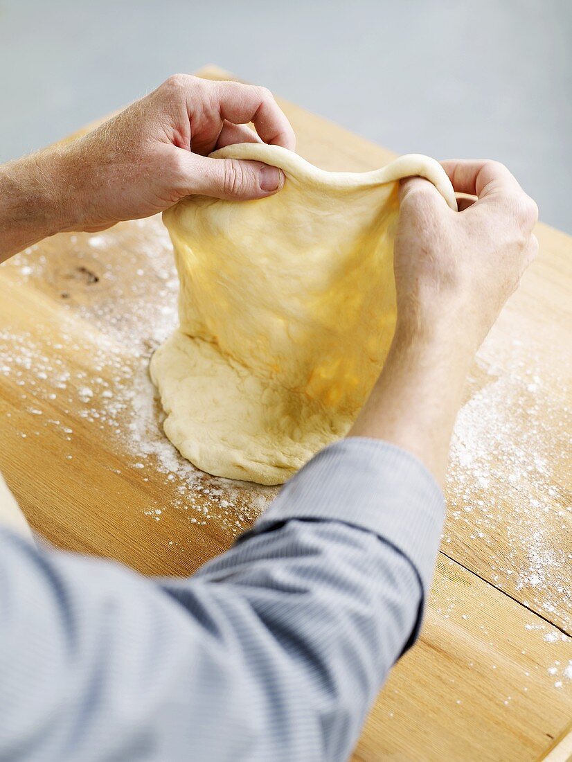 Making pizza dough (pulling the dough)