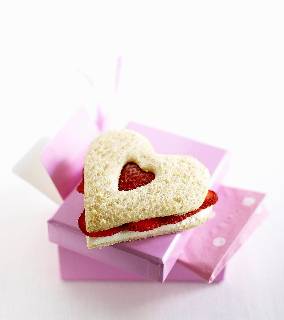 Heart-shaped strawberry and soft cheese sandwich