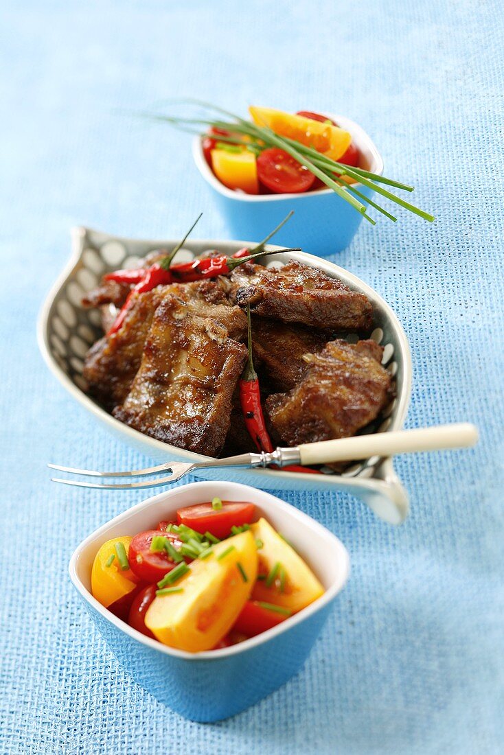 Grilled spare ribs with chillies and tomato salad