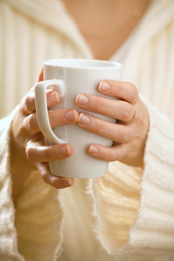 Frau hält einen Kaffeebecher