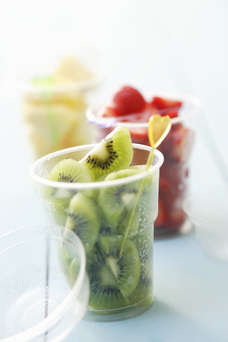 Assorted fruits with cocktail sticks in plastic tubss