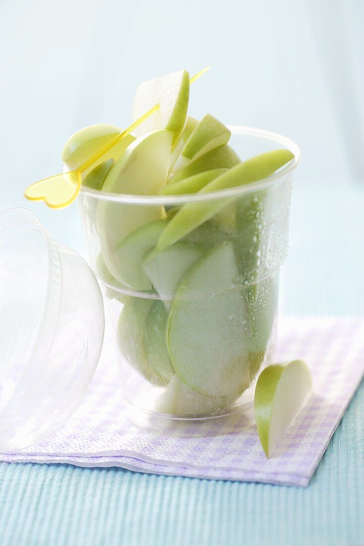 Slices of Granny Smith apples, cocktail stick in plastic tub