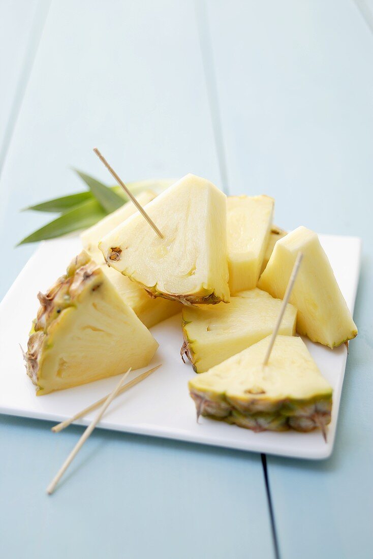 Pieces of pineapple with wooden cocktail sticks