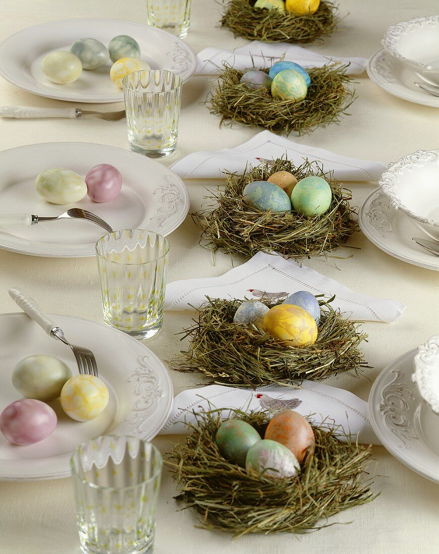 Marbled eggs in Easter nests on laid table