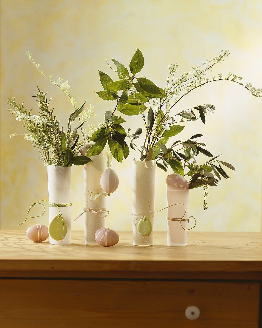 Herbs and flowering branches with Easter eggs in glasses