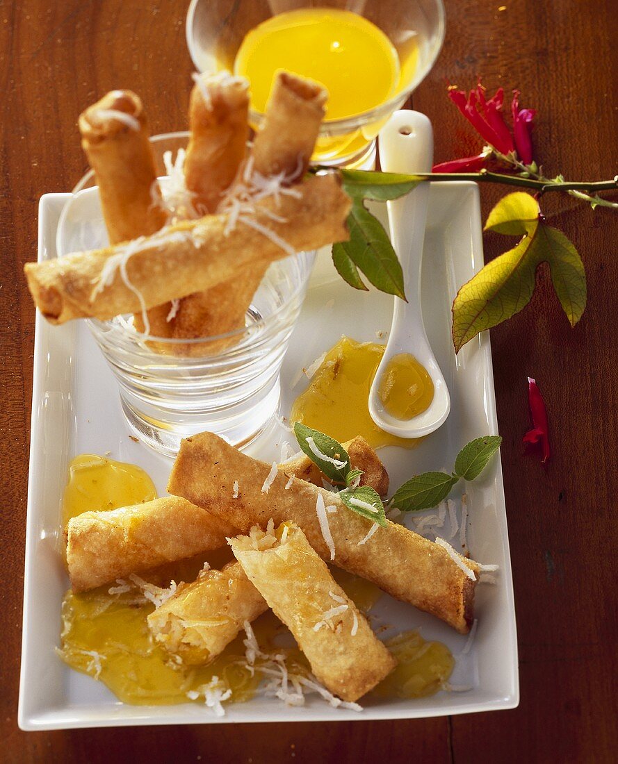 Coconut rolls with mango filling and passion fruit sauce