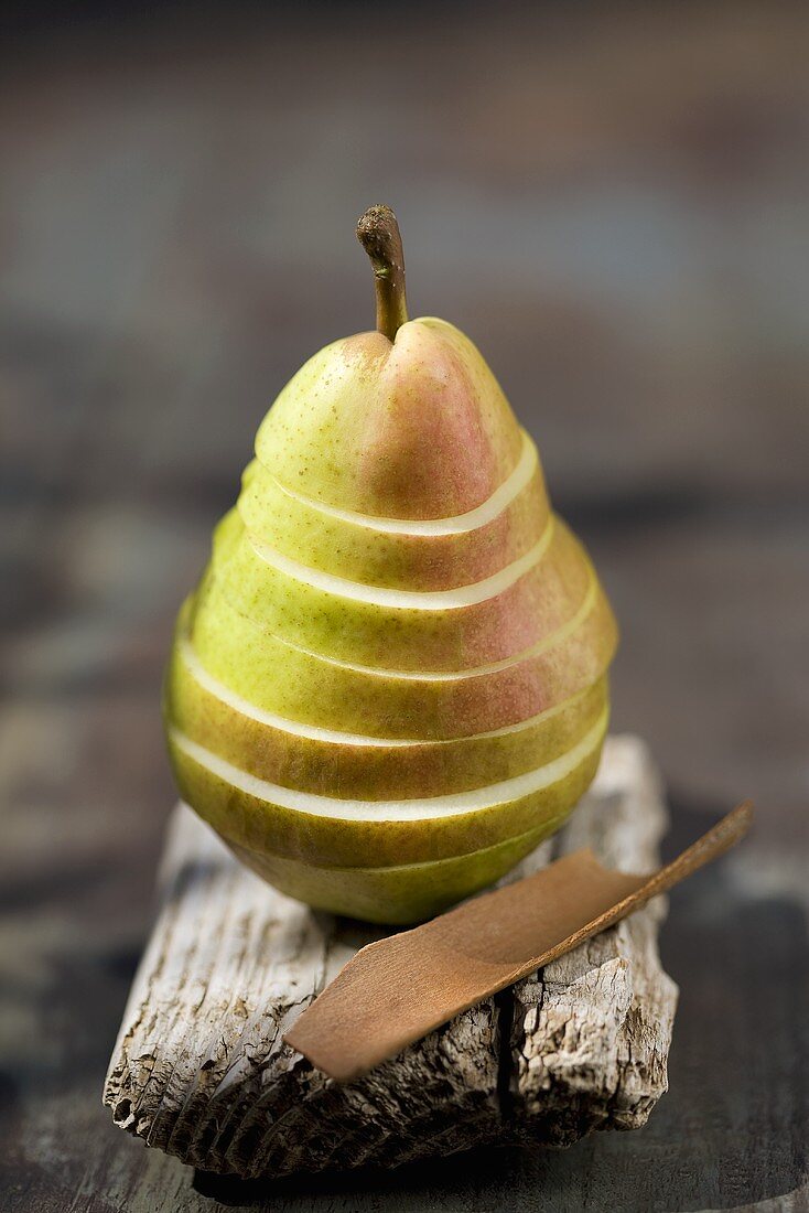 A sliced pear and cinnamon bark