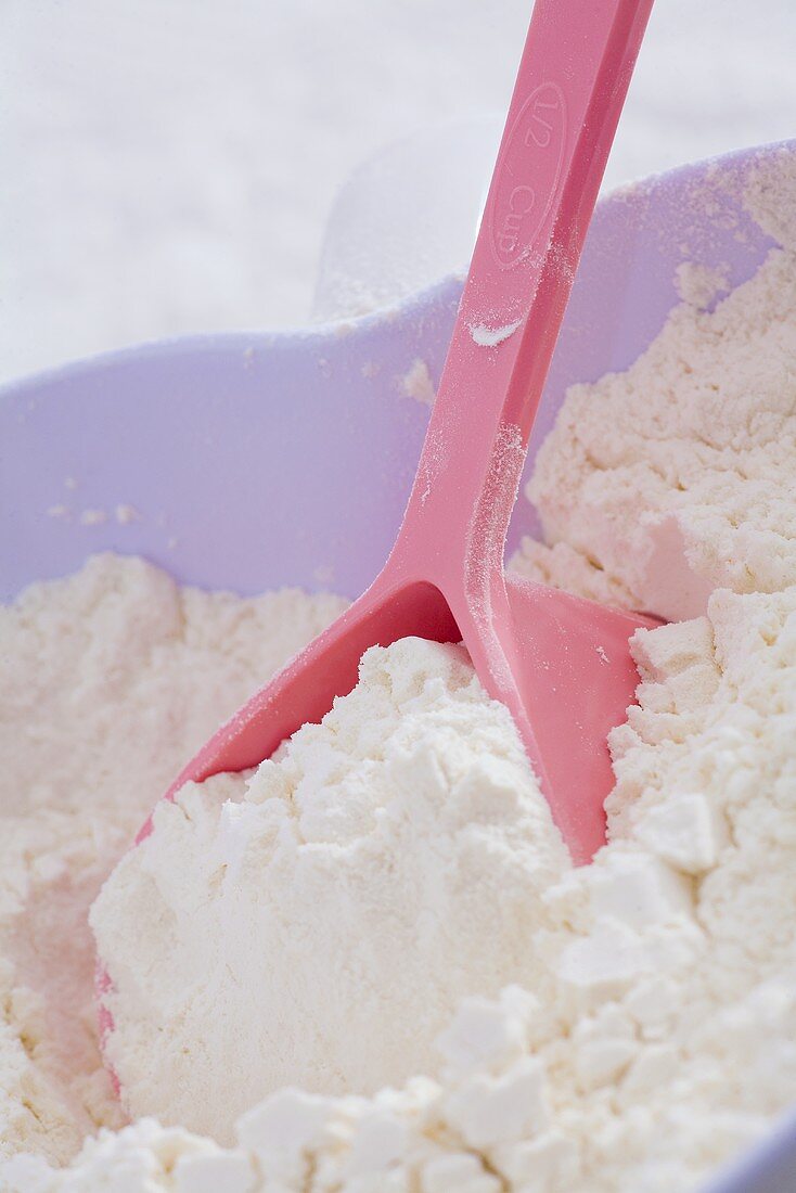 Flour with spoon in heart-shaped bowl