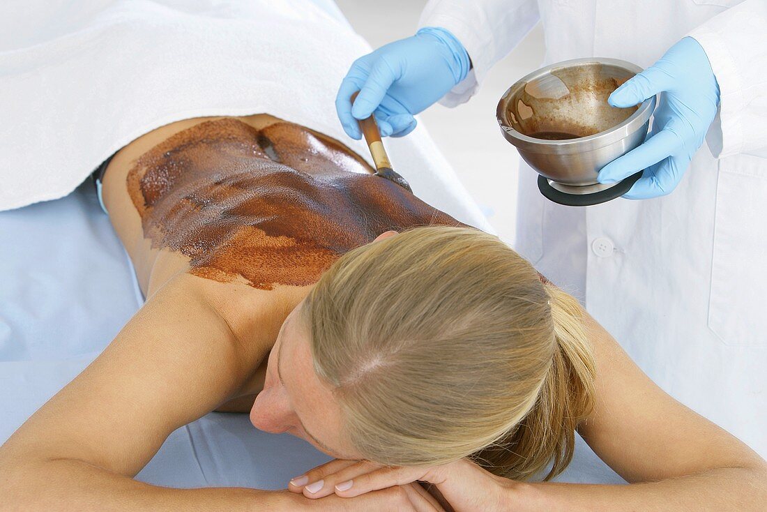 Applying a chocolate mask to someone's back