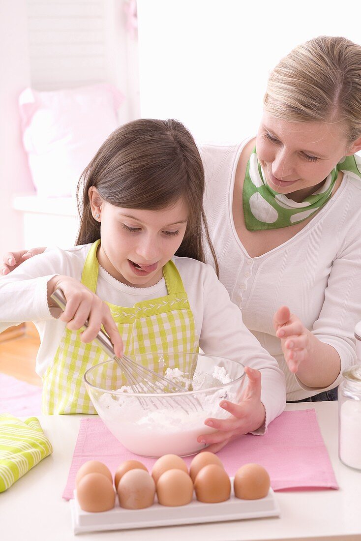 Mutter und Tochter schlagen Eischnee