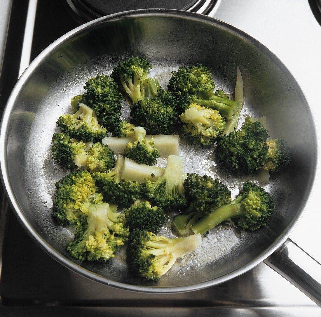 Sweating blanched broccoli in a frying pan