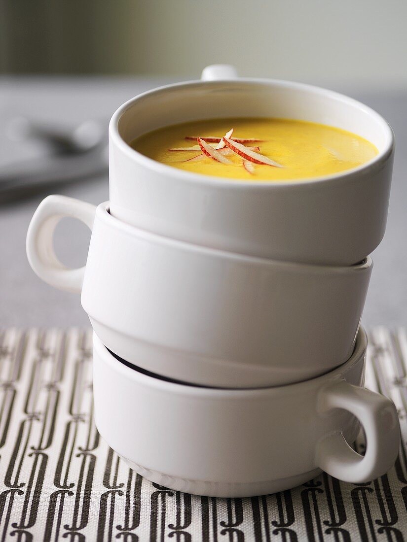 Pumpkin soup with slivers of apple in soup cups