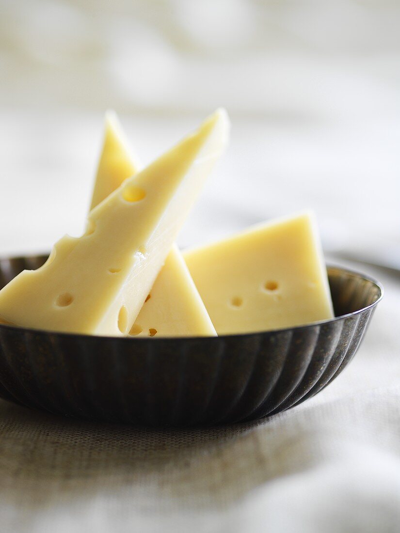 Emmental cheese, three pieces in a dish