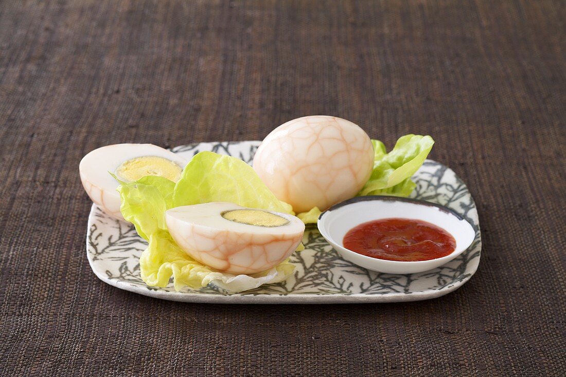 Tea eggs (eggs boiled with tea leaves) and chilli sauce