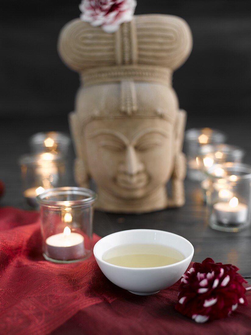 Green tea with tealights and stone figure