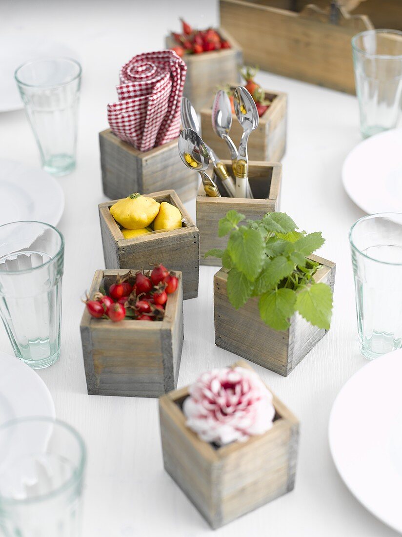 Dahlia, rose hips, baby patty pan squashes in wooden boxes