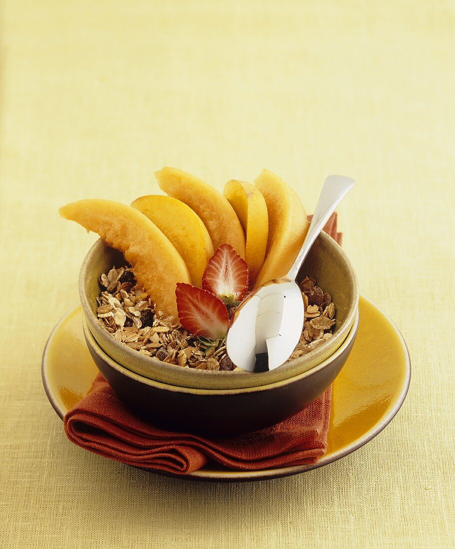 Muesli with melon and peach slices and strawberries